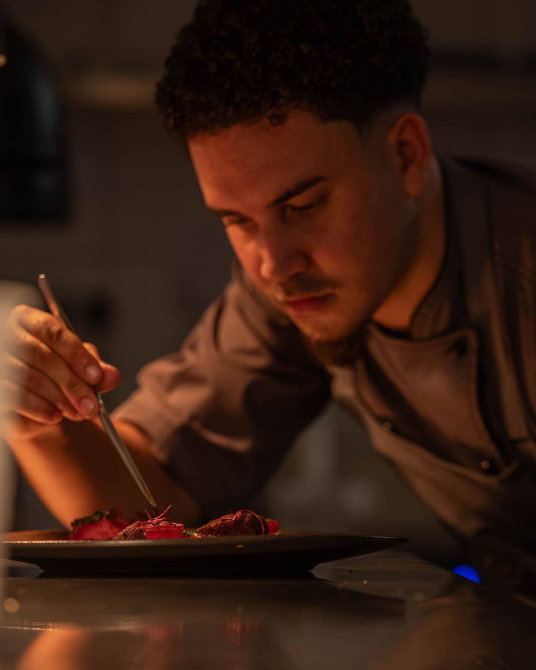 Chef Mordecai Brauns preparing a dish at Sanctuary Mandela