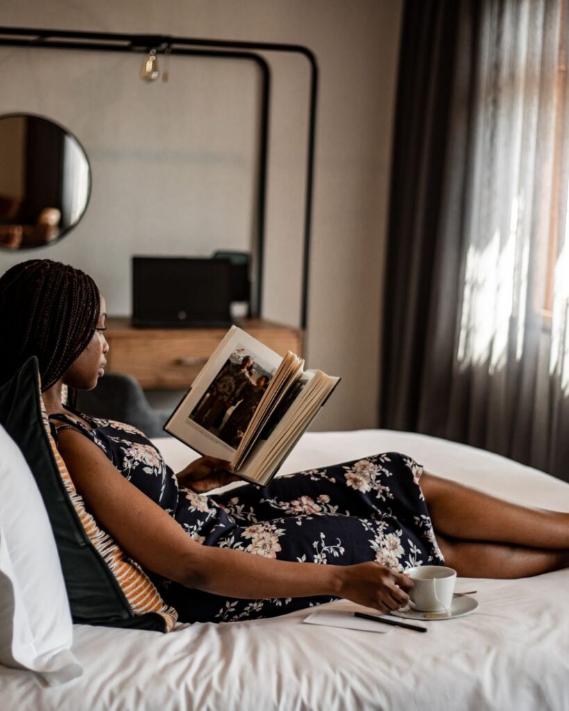 Woman reading a book in her hotel room at Sanctuary Mandela